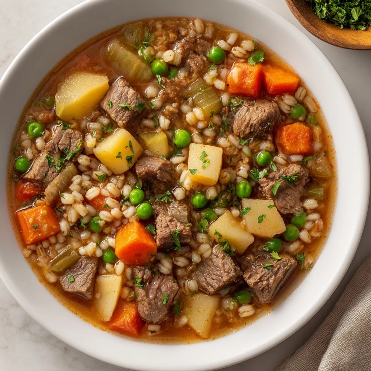 A close-up of a rustic, savory one-pot hearty beef and barley soup, highlighting the barley's texture.