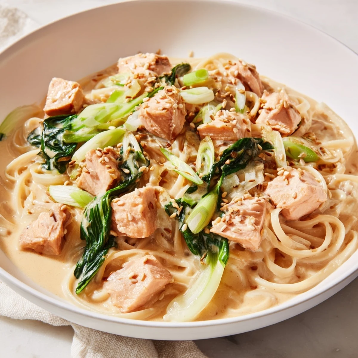 Delectable miso butter salmon pasta with glistening salmon pieces and fresh bok choy.
