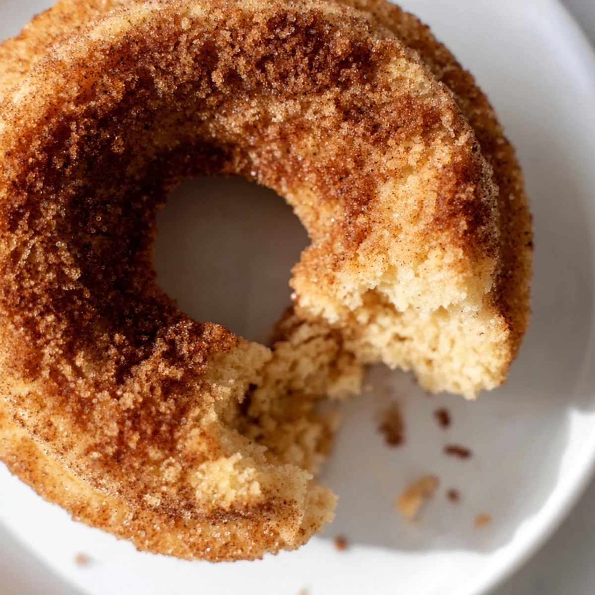 Freshly air fried Air Fryer Cinnamon Sugar Donuts glistening with melted butter and a heavy dusting of sweet cinnamon sugar.  