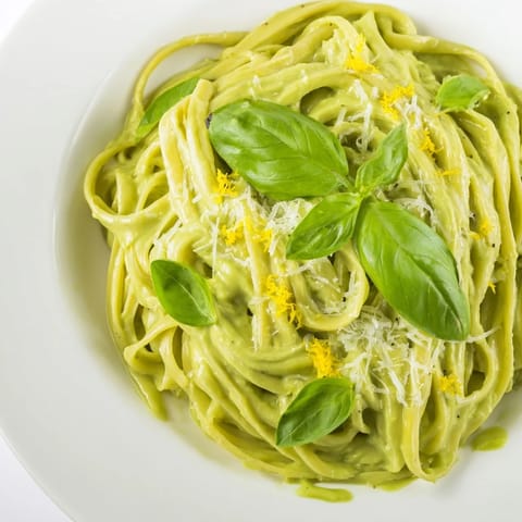 A close-up shot of the creamy avocado pasta, showing the velvety sauce coating each noodle perfectly.