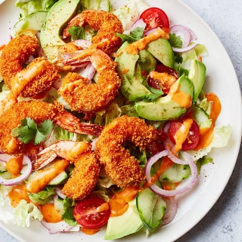 This Spicy Crispy Shrimp Salad features perfectly fried shrimp, drizzled with zesty sriracha-lime dressing.