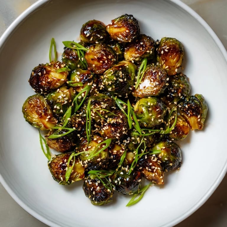 Savory and sweet Honey-Soy Glazed Brussels Sprouts, glistening with glaze and sprinkled with sesame seeds.